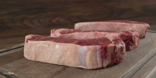 The three seasoned New York strips laid out before cooking, showing the beautifu