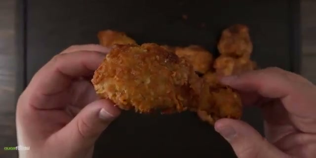 Both batches of finished fried chicken spread out on the table, hero shot of the