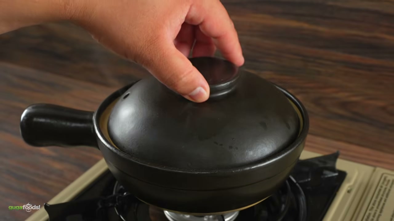Clay pot with chicken and mushrooms cooking, showing the crispy rice bottom form