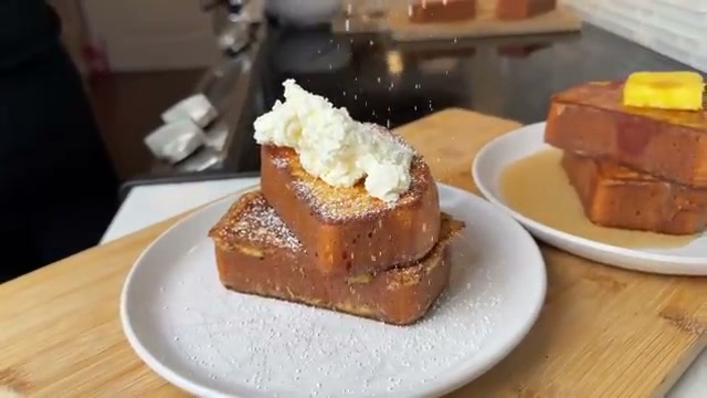 Finished plated French toast with all toppings: butter, syrup, whipped cream